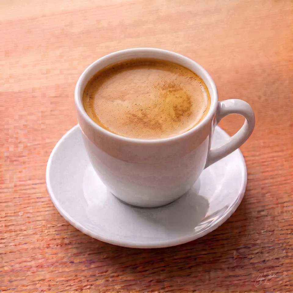 A freshly brewed Americano coffee with a rich, golden crema, served in a classic white ceramic cup and saucer.